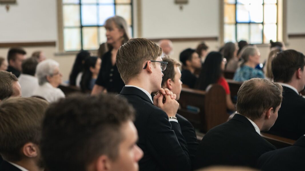 A seminarian of St. Joseph's House of Formation kneels in prayer in the pew.