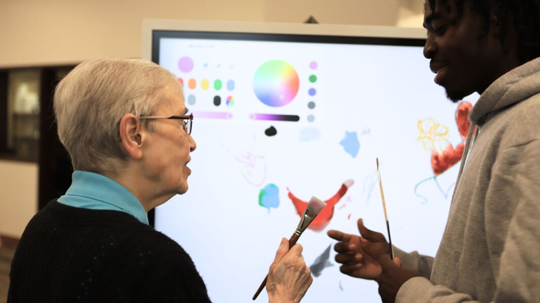 Newman student Eventz Malaska shows Sister Mary Kevin, ASC, how to use the smart boards.