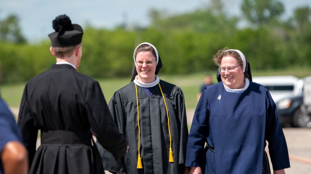 Swantek (center) smiles to Grelinger following Newman commencement in May.