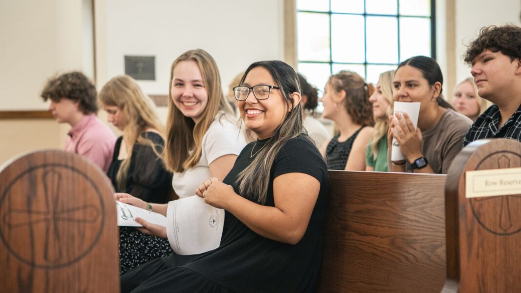 First-year student Grace Hertel (left) sits with student Melissa Arguijo during the Mass of the Holy Spirit and Matriculation Ceremony.