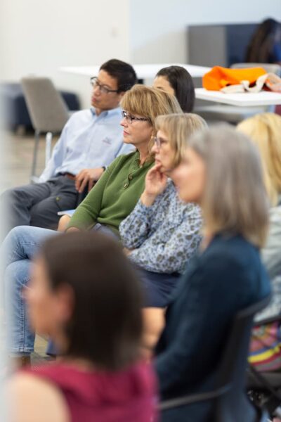 Several faculty members listen as another faculty member shares.