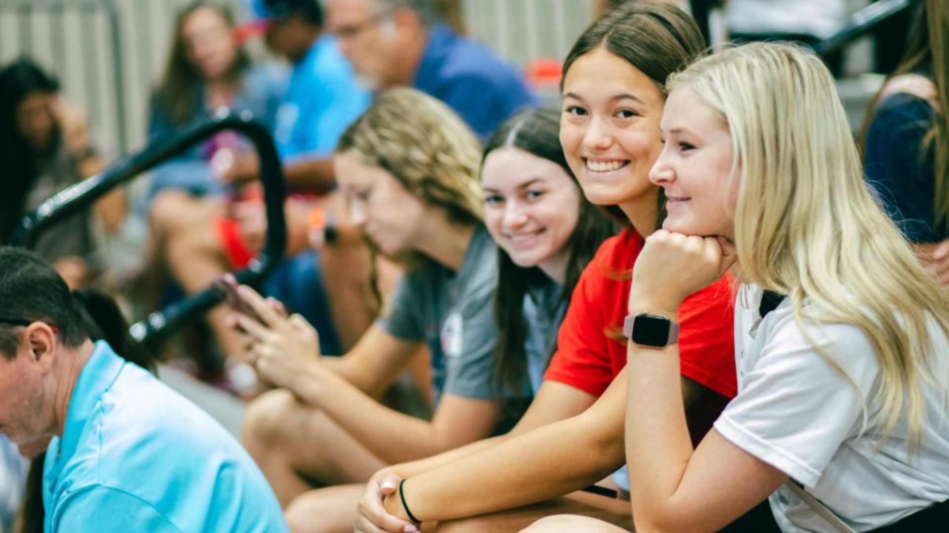 Students smile from the bleachers at Newman University