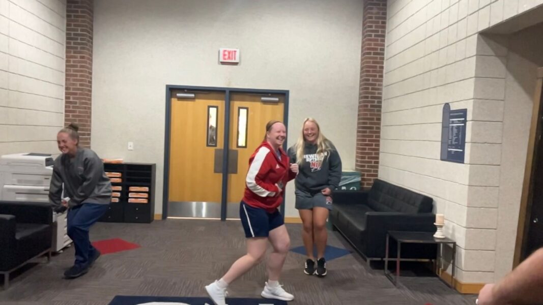 (From left to right) A screenshot from the dodgeball video shows Bonython, women's basketball coach Amy Briggs and Schreiner outside the athletics offices. 