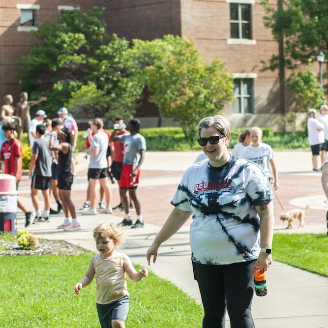 Johnston (center) outstretches a hand toward her son at the Newman Color Run.