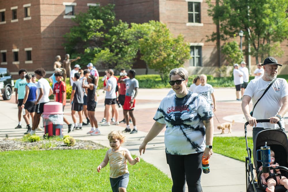 Johnston (center) outstretches a hand toward her son at the Newman Color Run.