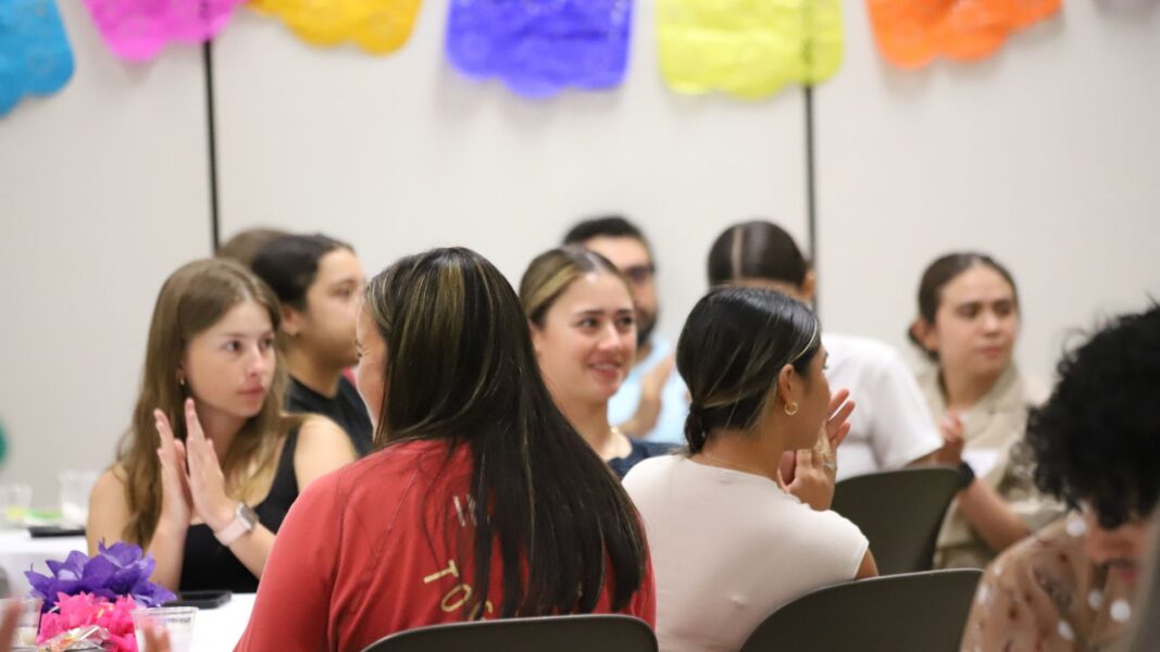 Attendees listen and applaud as panelists share during La Cadena.