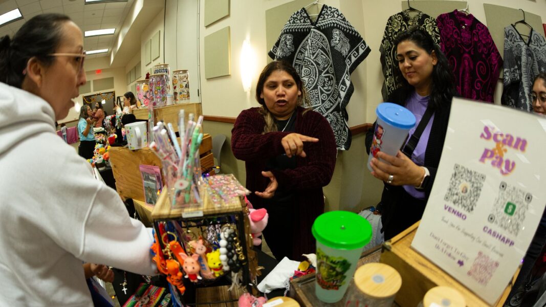 A guest buys artwork, clothing and knick-knacks from a local vendor during the event.