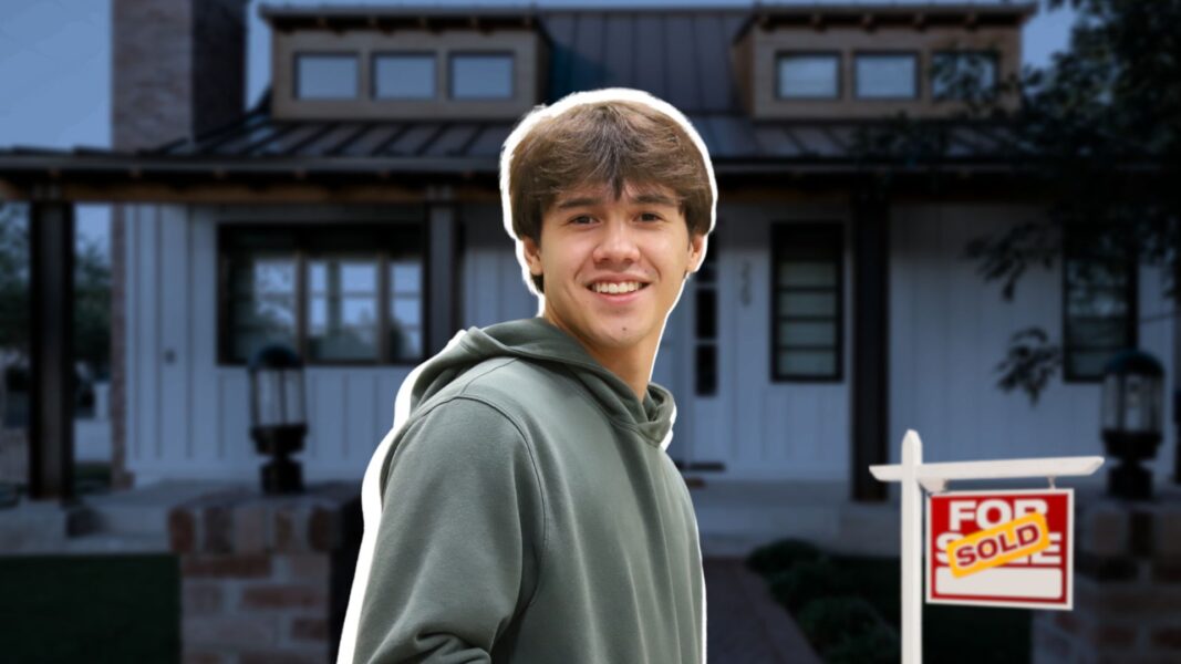 Flanigan in front of a house with a "sold" sign in front of it.