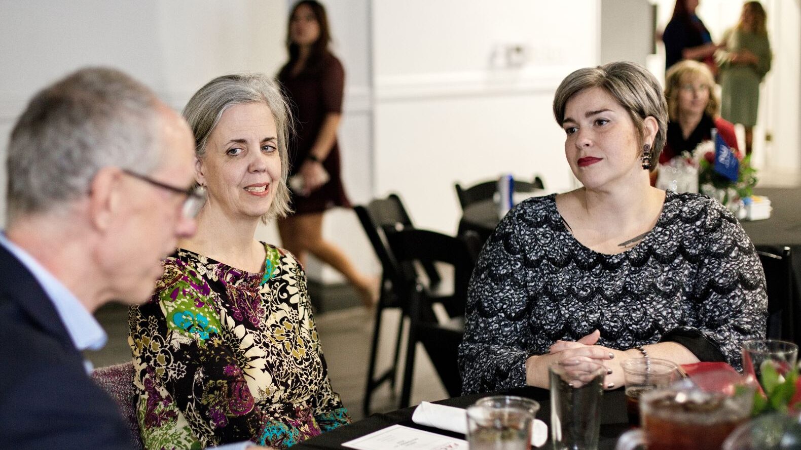 Faculty mingle at their tables.