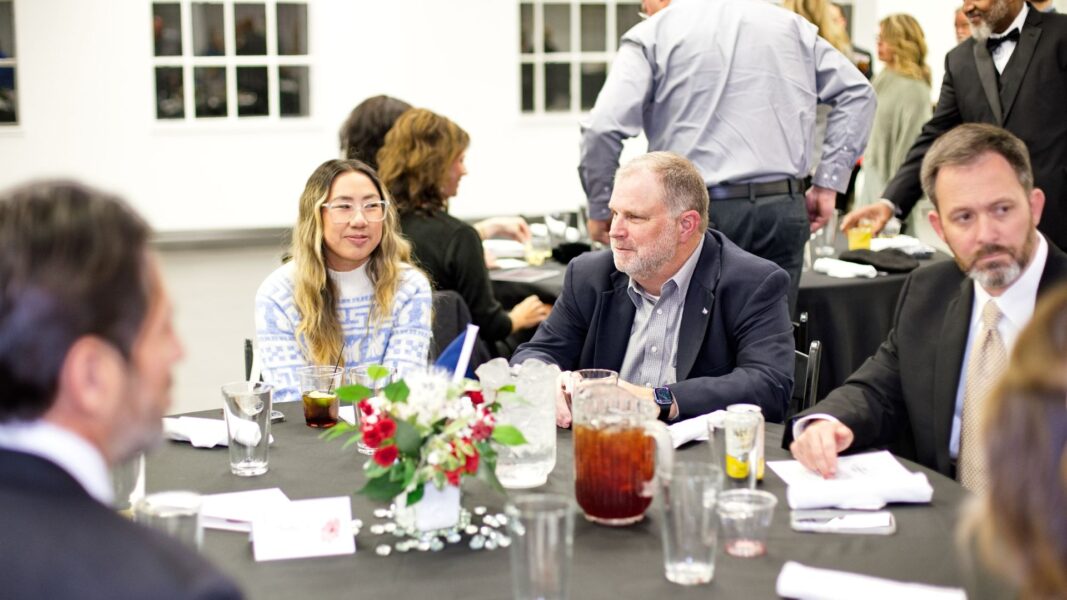 Director of the Radiologic Technology program Jeffery Vaughn sits at a table with guests and fellow faculty.