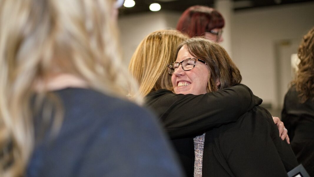 McCoy is embraced by a fellow faculty member after accepting her award.