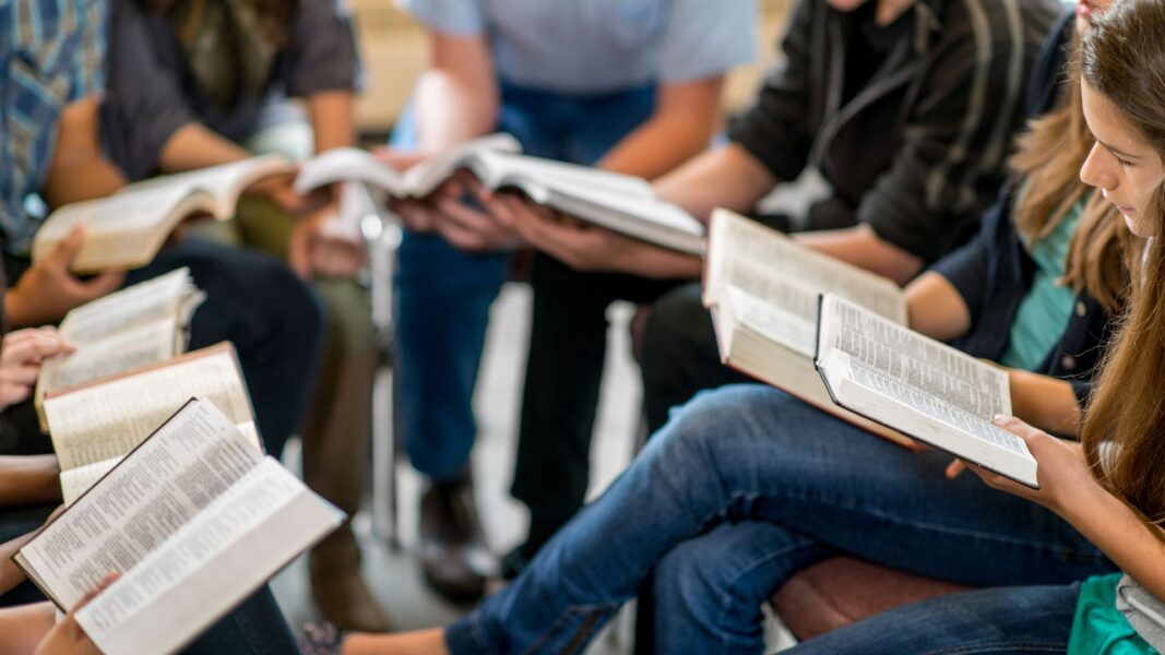 A group of individuals read passages from the Bible