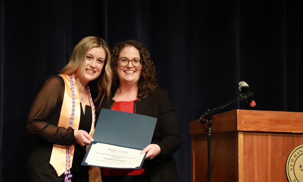 Nursing student receives certificate at pinning ceremony.