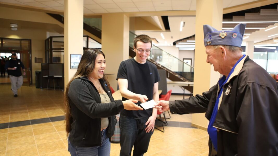 Lindsay Espinosa-Pablo and Brandon Welch accept a scholarship check from veteran Fred Howard on behalf of the 40&8 Military Honor Society.