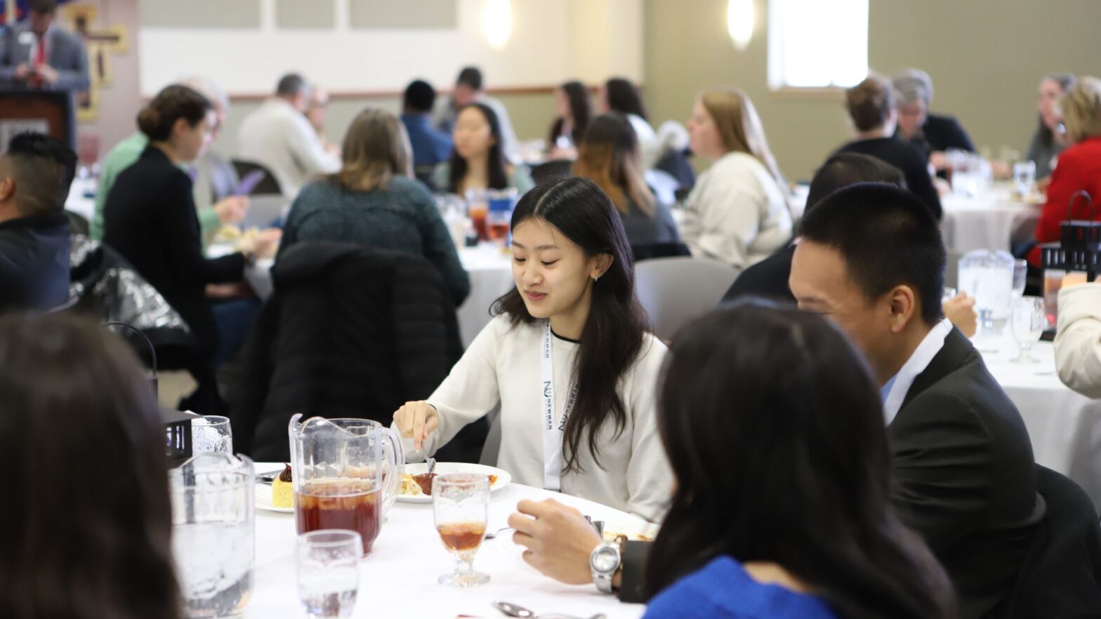 A student enjoys lunch at a table with family members during the scholarship interview day at Newman University.