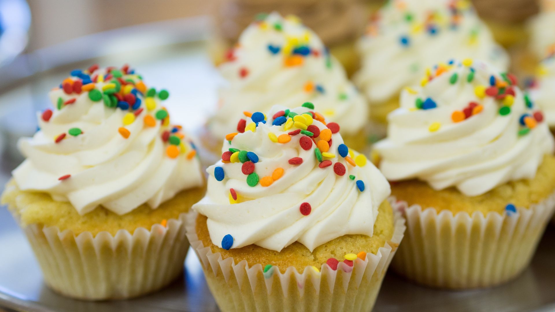 cupcakes with white frosting and colorful sprinkles