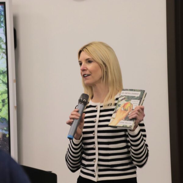 Hane, holding a book, addresses faculty members during a lightning session in the Center for Teaching and Learning in Dugan.