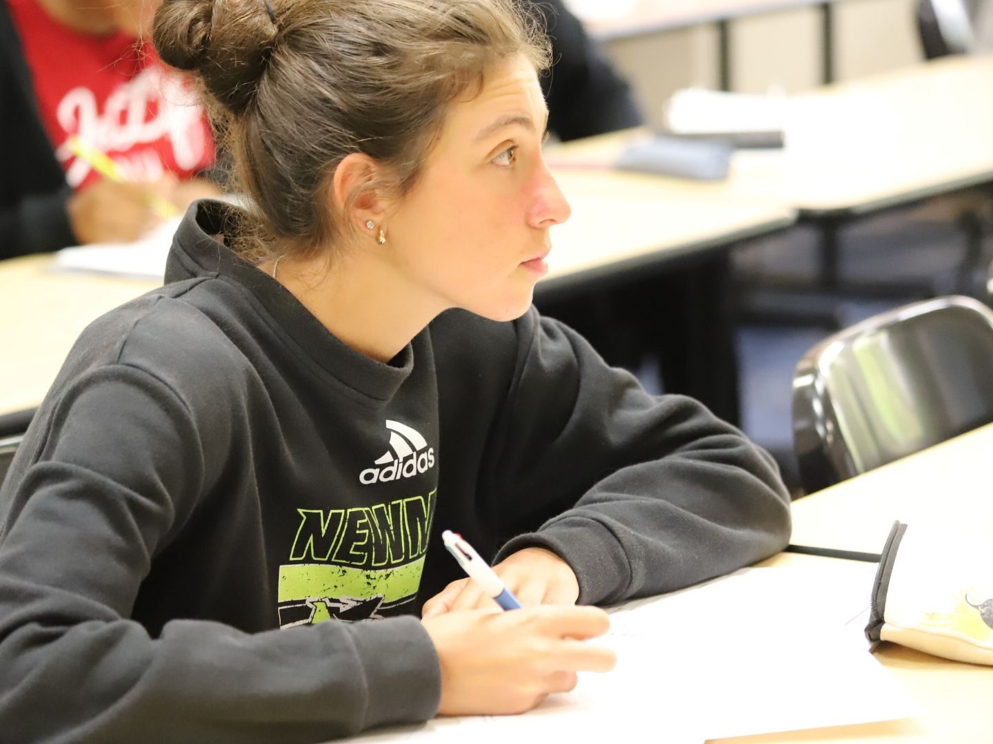 A student takes notes during a trigonometry class at Newman University.