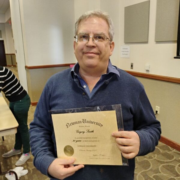 Smith receives a certificate for 30 years of teaching at Newman University.