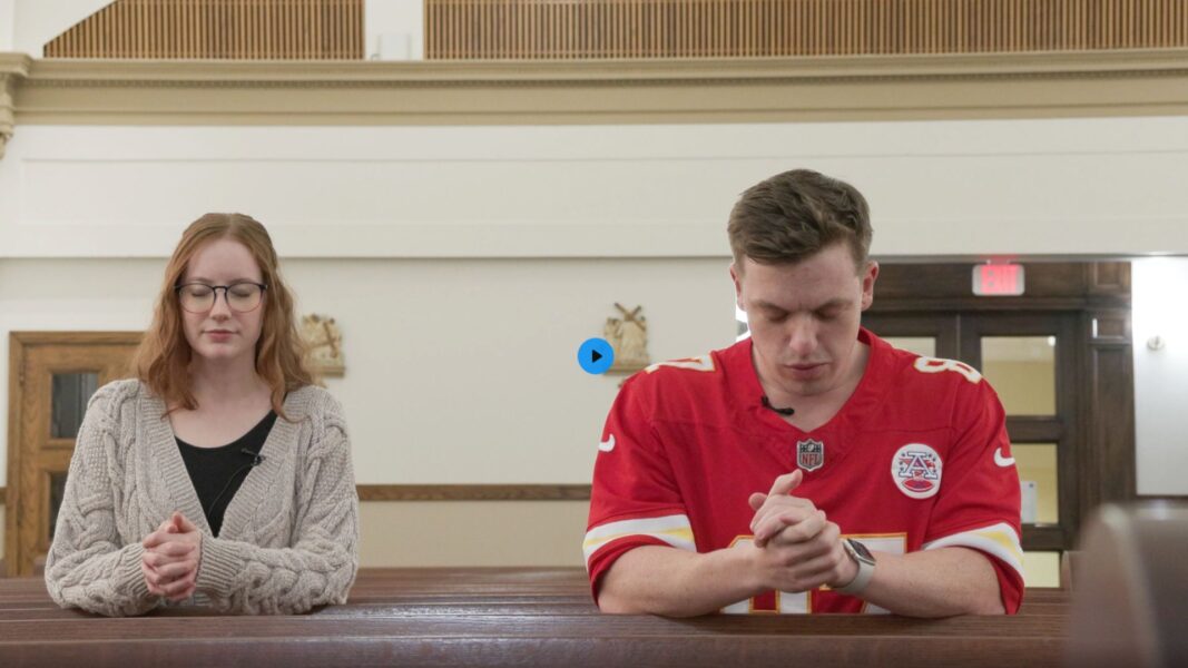 Two people (a man and a woman) pray in St. John's Chapel