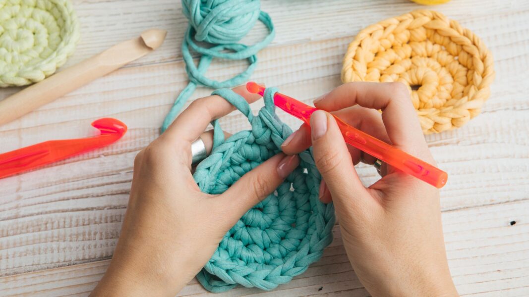 person crocheting with blue yarn