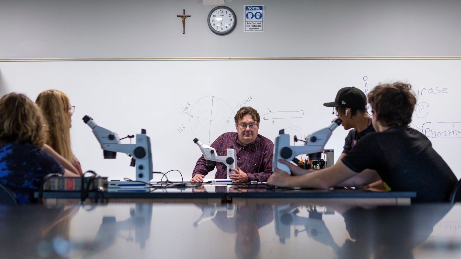 Goad helps students with research in a Newman University lab setting.