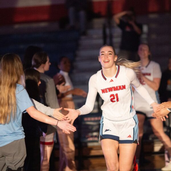 The women's basketball team runs onto the court.