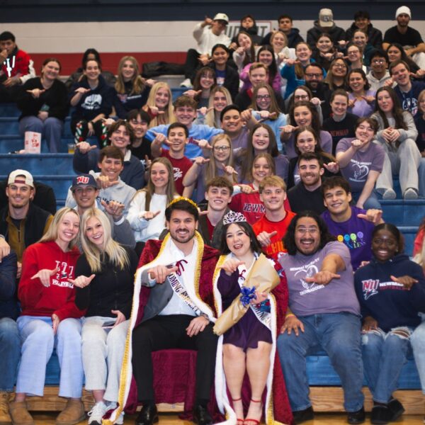 The Newman University student section shows off their "Jet" signs alongside newly crowned king Juan Carlos Cordova and queen Andrea Fuentes.