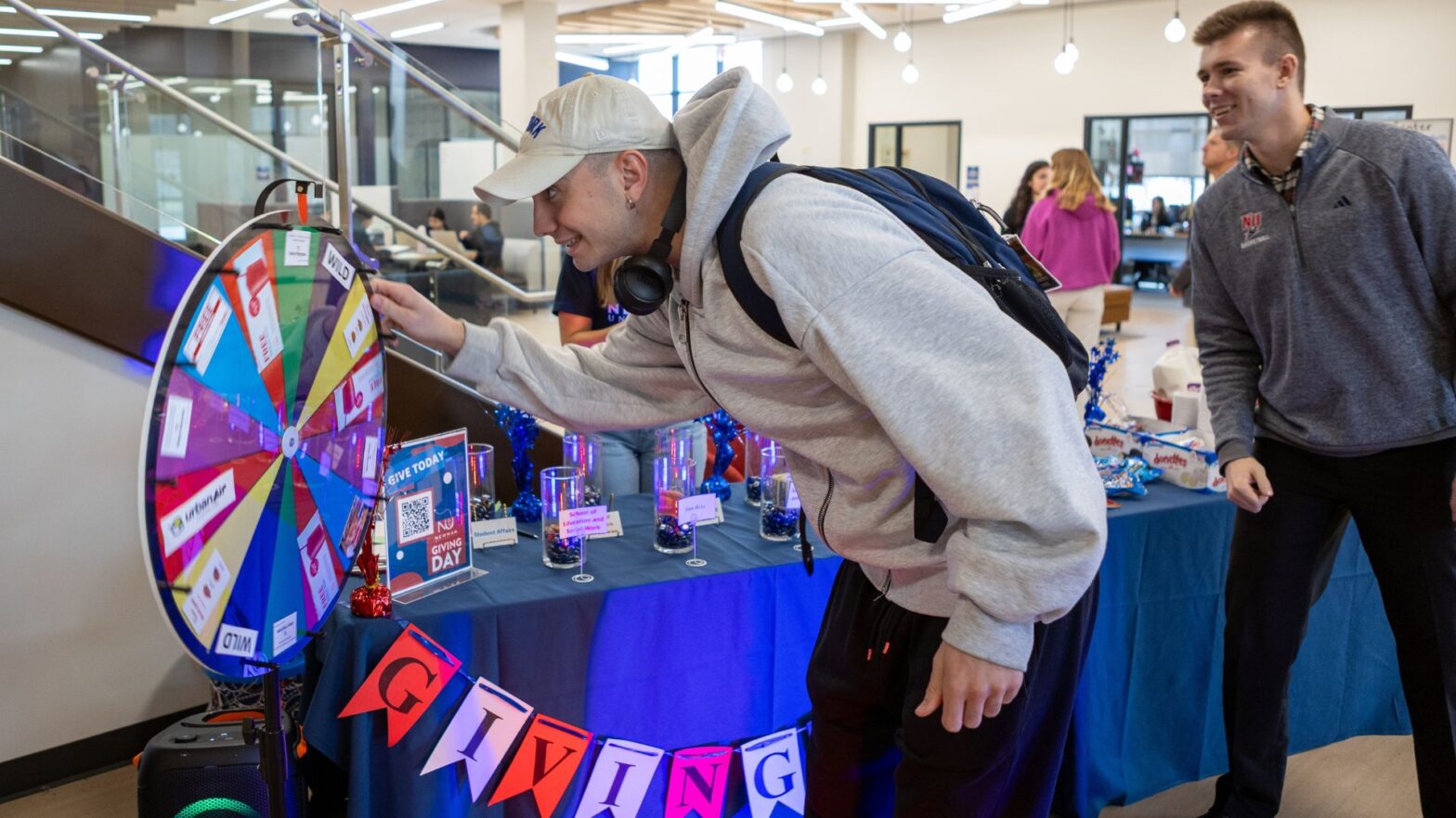 A student spins the wheel of prizes at the student booth for making a donation during Giving Day.