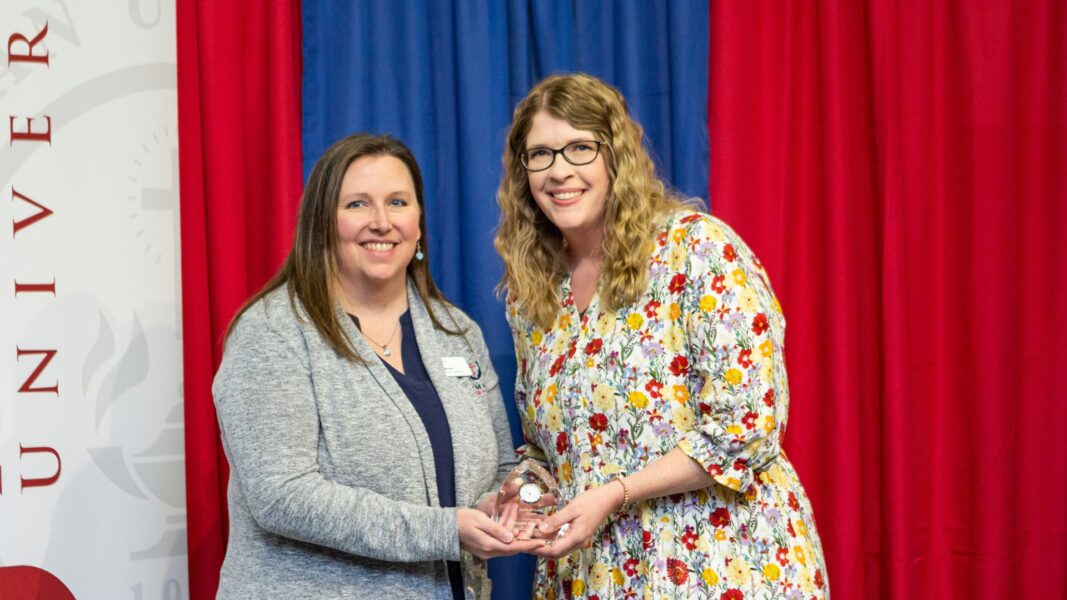 Lies accepts the Spirit of Acuto Award from Newman Director of Alumni Relations Dana Beitey.