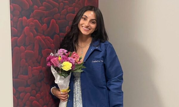 Isabella Torres in labcoat in Bishop Gerber Science Center on Newman University campus
