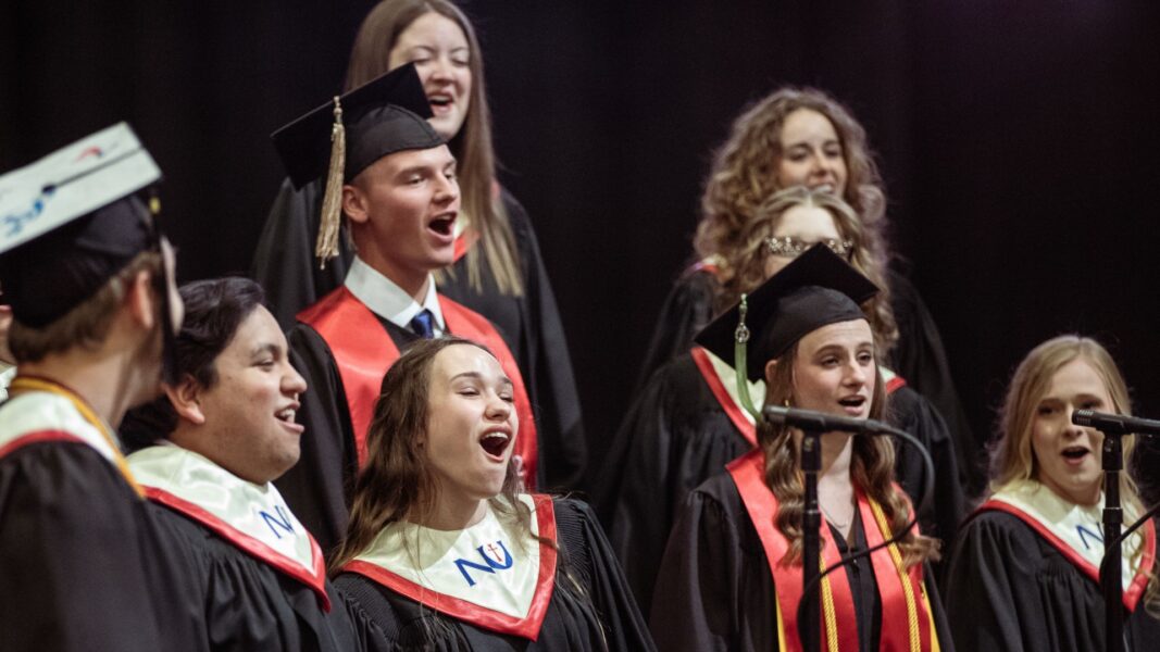Isaac and Erika wear their graduation caps, gowns and stoles as they give their final chorale performance during Newman University's commencement ceremony on May 17.