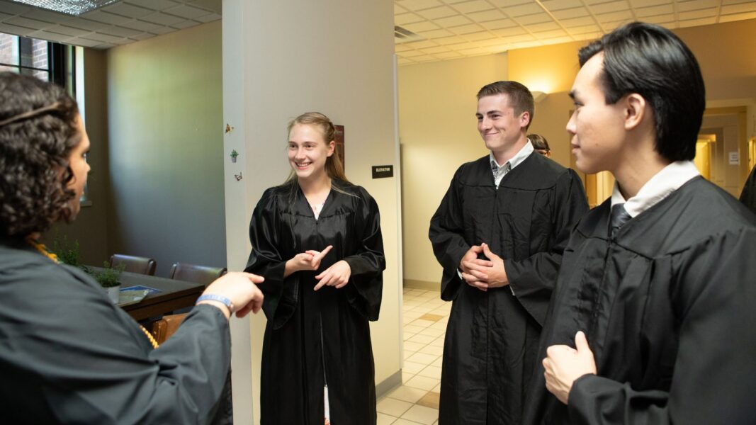 Sponsel (second from right) converses with fellow graduates before Baccalaureate Mass.