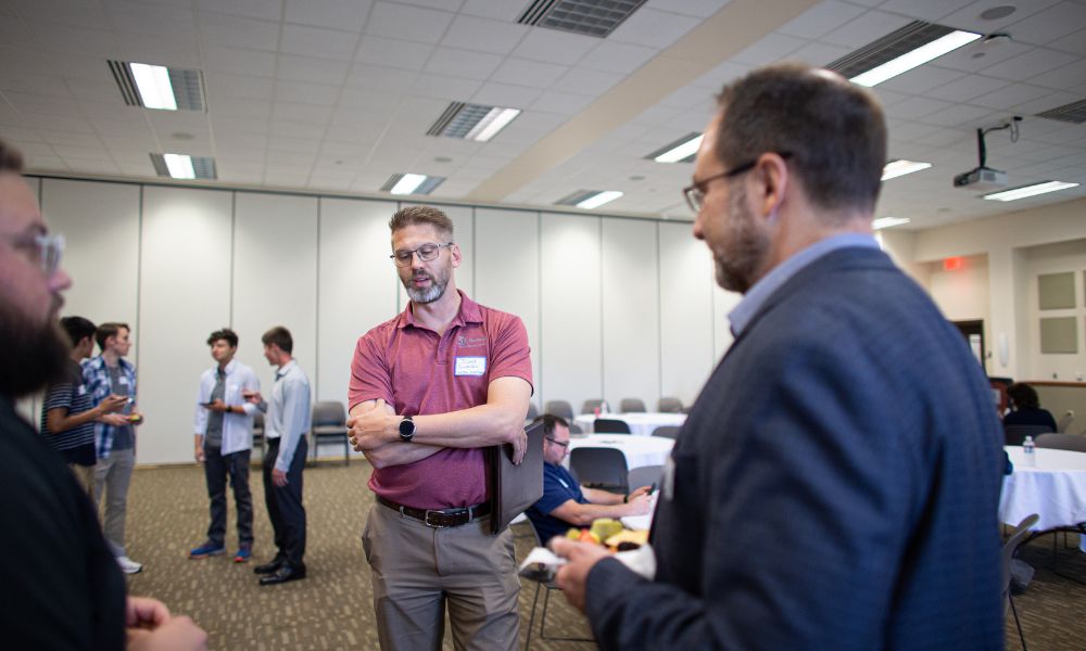 Attendees network following a School of Business & Technology professional event.