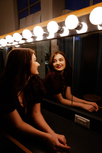 Brown in front of a dressing room mirror