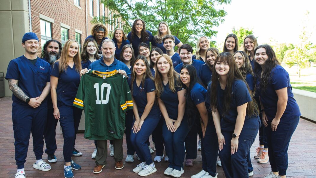 Herd (front row, far right) and classmates surprised Jeffery Vaughn, director of the radiologic technology program, with a Packers jersey as an end-of-semester gift.