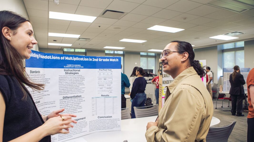 Kindred shares her Scholars Day research with fellow Newman graduate Daniel Cubias Arteaga.