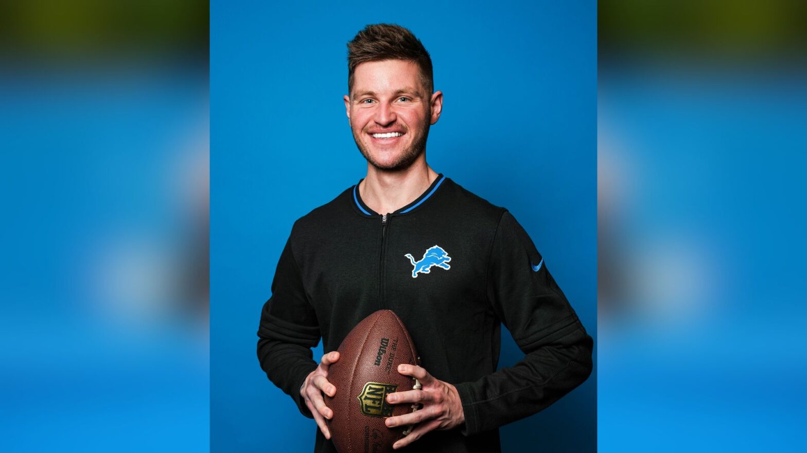 Campbell holds a football while wearing Lions gear