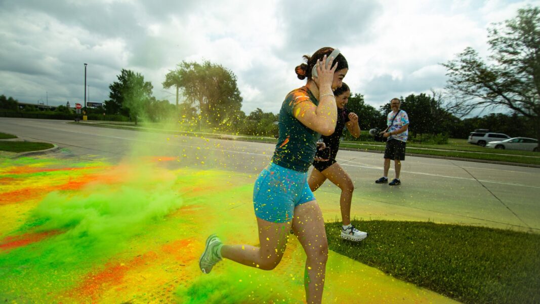 Students run through a color zone during the campus 5k.