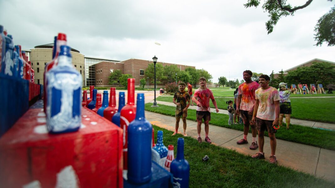 A ring flies in the air during the ringtoss event featuring hand-painted, Newman-themed bottles.