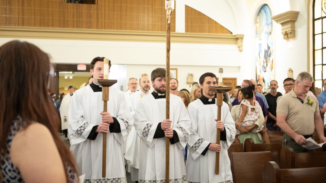 Three seminarians of the Catholic Diocese of Wichita enter St. John's Chapel for Mass.