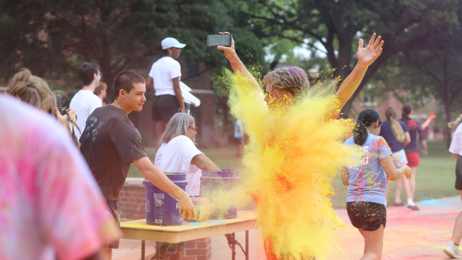 Student Colby Schreiner gets blasted with colored powder during Newman's 2025 Color Run.