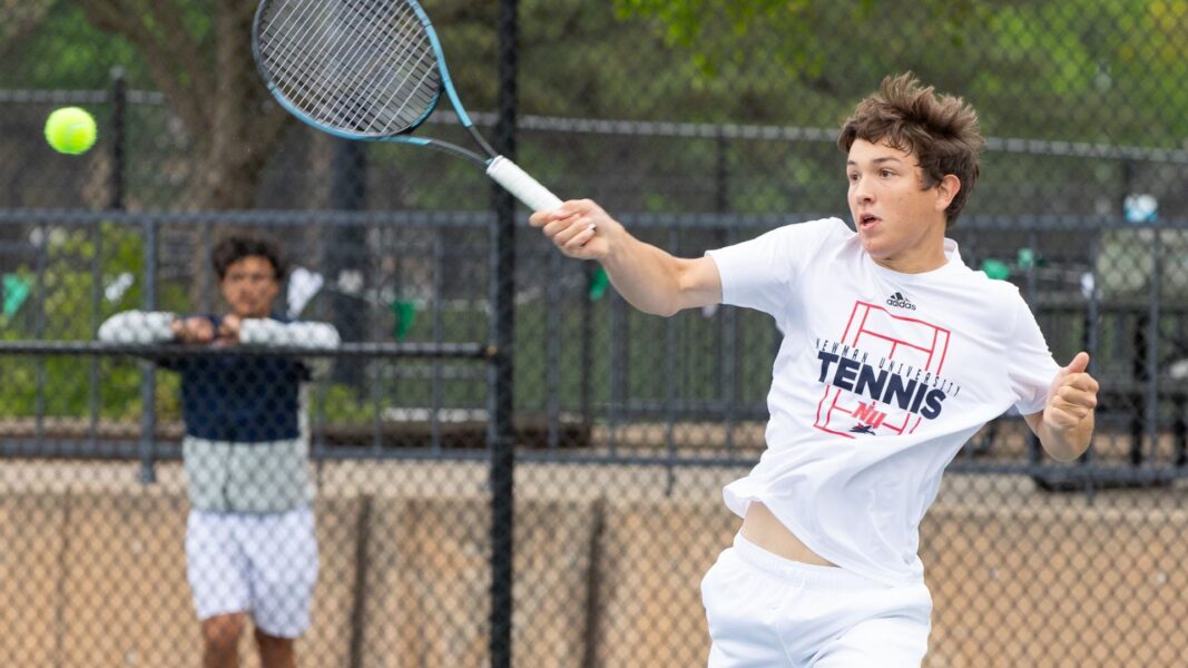 A Newman University tennis player serves the ball. (Courtesy photo: Richard Rico)