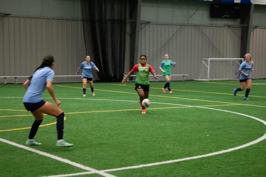 The Newman women's soccer team practices at an indoor facility.