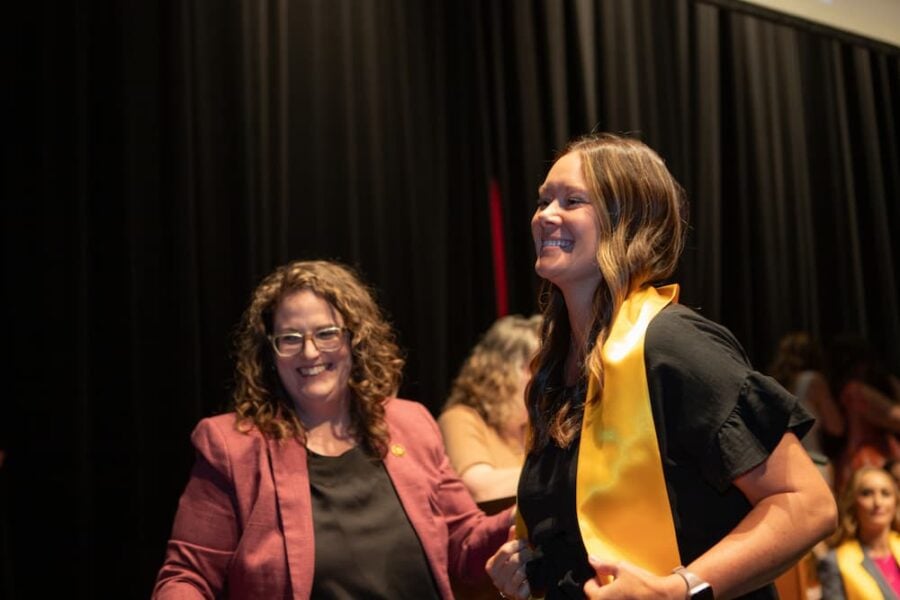 Tyrell smiles after pinning a School of Healthcare Professions graduate in May 2025.