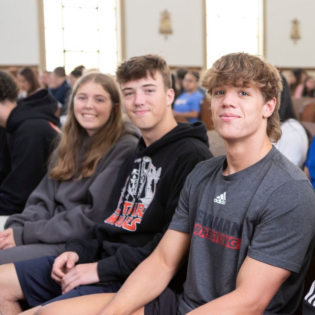 Students smile from the pews of St. John's Chapel.