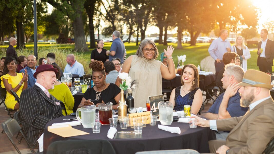 Advanced Standing Coordinator Candace Davis waves from her table at Party on the Plaza.