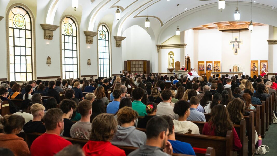 Jagger addresses the chapel filled with new Newman students.