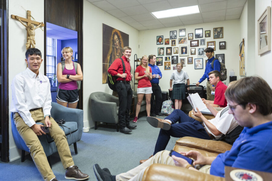 Photo of the original Campus Ministry office, showing it's previous saint wall of around 30 smaller, framed saint photos.