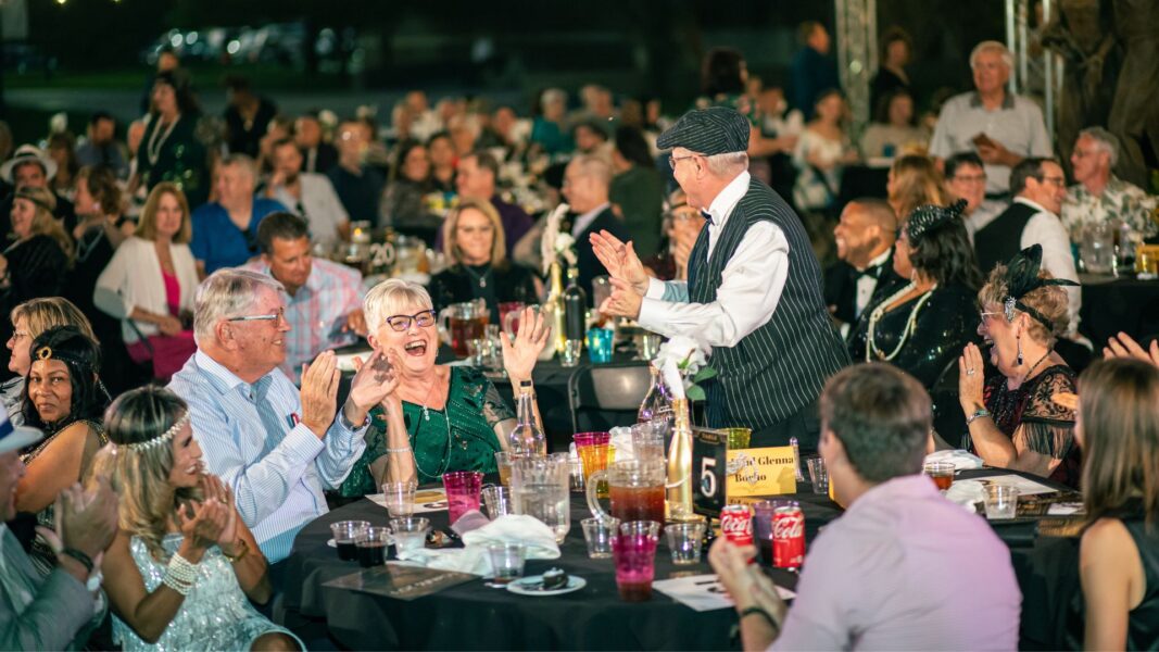 The crowd at Party on the Plaza 2024 cheers during the live auction portion of the evening.